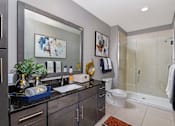 Thumbnail 25 of 62 - Luxury bathroom with granite countertops, glass shower and linen closet at Xenia Apartments in Golden Valley, Minnesota