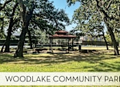 Thumbnail 35 of 42 - A gazebo sits in the middle of a park with trees surrounding it.