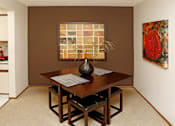 Thumbnail 8 of 35 - Spacious dining room with colored feature wall, and bright white kitchen with tile floor at LionsHead Apartments in Omaha, Nebraska