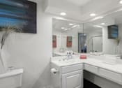Thumbnail 13 of 25 - Spacious bathroom with oval soaking tub with glass enclosure, cultured marble vanity, glass shower, and built-in vanity at Tuscany Park Apartments in Houston.
