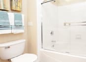Thumbnail 30 of 31 - Luxury bathroom with tiled floors, glass shower, and oval soaking tub at Rockledge Oaks Apartments in Lincoln, Nebraska