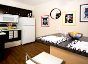 Thumbnail 24 of 27 - Kitchen with wood pattern floors, black kitchen cabinets, and spacious dining room at Kensington Woods Apartments in Omaha, Nebraska