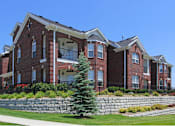 Thumbnail 24 of 31 - Luxury apartments with spacious balcony, red brick exterior, and beautiful landscaping at Rockledge Oaks Apartments in Lincoln, Nebraska