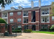 Thumbnail 14 of 36 - Gated community luxury apartments with brick exteriors, private outside storage, French doors, and lush landscaping including beautiful chaste trees at Tuscany Apartments in Houston.