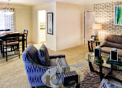 Thumbnail 2 of 19 - Spacious living room and dining room with white brick feature wall at Plantation apartments near the Galleria in Houston.