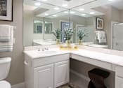 Thumbnail 11 of 31 - Luxury bathroom with tiled floors, glass shower, oval soaking tub, cultured marble vanity, and white cabinets in at Rockledge Oaks Apartments in Lincoln, Nebraska