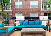 Thumbnail 29 of 36 - Luxury apartments with brick exteriors, pool-side lounge seating, and grilling area at Tuscany Apartments in Houston.