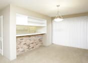 Thumbnail 11 of 19 - Spacious dining room with brick feature wall, built-in shelves, breakfast bar, and bright white kitchens at Plantation apartments near the Galleria in Houston.