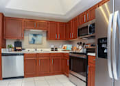 Thumbnail 5 of 22 - Spacious kitchen with stainless steel appliances, side-by-side refrigerator with water dispenser, recessed ceiling, and lots of cabinet space at The Dorchester Apartments in Dallas Texas
