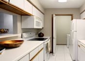 Thumbnail 24 of 30 - Kitchen with lots of cabinet space, lots of counter space, gray wall color, and full-size washer and dryer at The Vanderbilt Apartments in Omaha, Nebraska