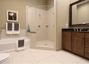 Thumbnail 32 of 42 - Spacious bathroom with oval soaking tub, separate shower with glass enclosure, and cultured marble vanity at Tuscany Walk Apartments in Houston