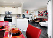 Thumbnail 3 of 31 - Luxury apartments with wood plank floors, spacious floor plan, white kitchen cabinets, gas fireplace, built-in shelves, and gray wall color at Rockledge Oaks Apartments in Lincoln, Nebraska