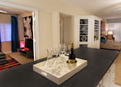 Thumbnail 29 of 41 - Spacious living room with colored feature wall, kitchen island, prep island, den or office space at Embassy Park Apartments in Omaha, Nebraska