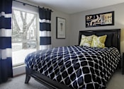 Thumbnail 23 of 30 - Spacious master bedroom with walk-in closet, master bathroom, and gray wall color at The Vanderbilt Apartments in Omaha, Nebraska