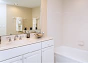Thumbnail 20 of 41 - Bathroom with white cabinets, soaking tub, and tiled floor at Embassy Park Apartments in Omaha, Nebraska