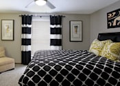 Thumbnail 14 of 30 - Spacious master bedroom with walk-in closet, master bathroom, and gray wall color at The Vanderbilt Apartments in Omaha, Nebraska