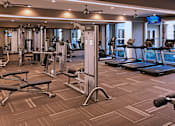 Thumbnail 34 of 42 - Luxury apartments with huge fitness center with multiple varieties of workout machines and equipment at Tuscany Walk Apartments in Houston Texas.
