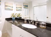 Thumbnail 11 of 34 - Luxury bathroom with oval soaking tub with glass enclosure, granite vanity top, and glass shower at Tuscany Row Townhomes in Houston.