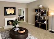 Thumbnail 34 of 38 - Spacious living room with oversized windows, lots of natural light, and woodburning fireplace at Woodlake Oaks Apartments in Houston.