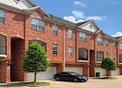 Thumbnail 2 of 34 - Luxury townhomes in a gated community with red brick exteriors and attached 2-car garages at Tuscany Row Townhomes in Houston.