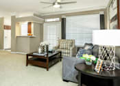 Thumbnail 19 of 36 - Spacious living room with wood-burning fireplace, crown molding, 9-foot ceilings, breakfast bar, ceiling fan, refrigerator with water and ice dispenser at Tuscany Apartments in Houston.