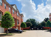 Thumbnail 10 of 34 - Luxury townhomes in a gated community with red brick exteriors and attached 2-car garages at Tuscany Row Townhomes in Houston.