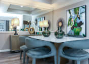 Thumbnail 4 of 22 - Dining room with mirror accent wall, recessed ceiling, wood plank floors, gray colored walls at The Dorchester Apartments in Dallas Texas