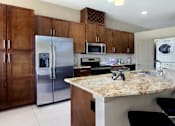 Thumbnail 19 of 46 - Luxury apartments with spacious kitchen, granite countertops, stainless steel appliances, built-in wine rack, kitchen island, front-loading washer and dryer and porcelain tile floor at Bellemeade Apartments in west Des Moines