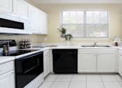 Thumbnail 25 of 38 - Luxury apartments with bright white kitchen, u-shaped kitchen, white cabinets, and side-by-side refrigerator at TurtleCreek apartments in West Des Moines, Iowa