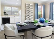 Thumbnail 8 of 38 - Spacious dining room with oversized windows, u-shaped kitchen with white cabinets, and side-by-side refrigerator at TurtleCreek apartments in West Des Moines, Iowa