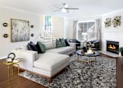 Thumbnail 1 of 26 - Spacious living room with wood plank flooring and wood-burning fireplace at Tuscany Villas Townhomes in Houston.