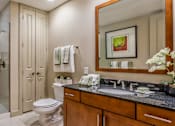 Thumbnail 31 of 36 - Luxury bathroom with granite countertops, glass shower and linen closet at Villa Piana Apartments in Dallas
