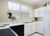 Thumbnail 26 of 38 - Luxury apartments with bright white kitchen, u-shaped kitchen, white cabinets, and side-by-side refrigerator at TurtleCreek apartments in West Des Moines, Iowa