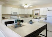 Thumbnail 4 of 27 - Spacious kitchen with lots of cabinet space, lots of counter space, white kitchen cabinets, bright white kitchen, porcelain tile floor, huge kitchen at Alpine Village Apartments in La Vista, Nebraska