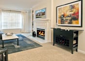 Thumbnail 22 of 42 - A living room with a fireplace and a painting on the wall.