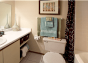Thumbnail 31 of 35 - Bathroom with extra storage space, built-in shelves, tile floors and tile showers at LionsHead Apartments in Omaha, Nebraska