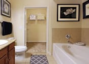 Thumbnail 6 of 37 - Spacious master bathroom with oval soaking tub, separate glass shower, and attached large walk-in closet at The Voss Apartments in Houston.