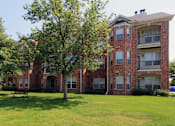Thumbnail 21 of 36 - Luxury apartments with red brick exterior, spacious balconies, lush landscaping, park-like setting, and scenic views at Lenox Village Apartments in Lincoln, Nebraska