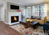 Thumbnail 1 of 36 - Living room with wood plank floors, gray wall color, wood burning fireplace, oversized window, and built-in shelves.
