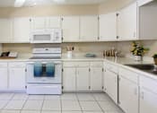 Thumbnail 22 of 27 - Spacious kitchen with lots of cabinet space, lots of counter space, white kitchen cabinets, bright white kitchen, porcelain tile floor, huge kitchen at Alpine Village Apartments in La Vista, Nebraska