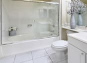 Thumbnail 12 of 38 - Luxury bathroom with tiled floors, oval soaking tub, built-in vanity, cultured marble vanity, glass shower and white cabinets in at TurtleCreek apartments in West Des Moines, Iowa