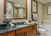 Thumbnail 20 of 36 - Luxury bathroom with granite countertops, glass shower and separate soaking tub at Villa Piana Apartments in Dallas