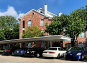 Thumbnail 48 of 73 - Gated luxury apartment community in north Dallas with red brick exteriors, covered parking, lots of trees, and beautiful landscaping at The Saxony Apartments