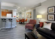 Thumbnail 25 of 36 - Luxury apartments with wood grain plank floors, dining room, u-shaped kitchen, mirror accent wall, built-in shelves, and breakfast bar at Lenox Village Apartments in Lincoln, Nebraska
