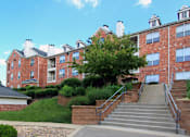 Thumbnail 23 of 38 - Luxury apartments with red brick exteriors, garages, and lush landscaping at TurtleCreek apartments in West Des Moines, Iowa