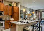 Thumbnail 2 of 36 - Luxury apartments next to the Galleria in Dallas with granite countertops, stainless steel appliances, built-in wine rack, kitchen island, and porcelain tile floor at Villa Piana Apartments in Dallas