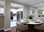 Thumbnail 32 of 38 - Spacious dining room, mirror accent wall, white cabinets, u-shaped kitchen, stainless steel appliances, wood plank floor and side-by-side refrigerator at TurtleCreek apartments in West Des Moines, Iowa