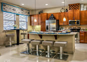 Thumbnail 9 of 36 - Luxury apartments with spacious kitchen with granite countertops, stainless steel appliances, built-in wine rack, kitchen island, and porcelain tile floor at Villa Piana Apartments in Dallas