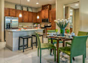 Thumbnail 18 of 36 - Luxury apartments next to the Galleria in Dallas with granite countertops, stainless steel appliances, built-in wine rack, kitchen island, and porcelain tile floor at Villa Piana Apartments in Dallas