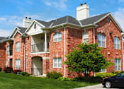Thumbnail 23 of 36 - Luxury apartments with red brick exterior, spacious balconies, lush landscaping, park-like setting, and scenic views at Lenox Village Apartments in Lincoln, Nebraska